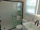 Featuring an enclosed glass shower, this bathroom provides great natural light from the window at 5531 Autry Rd, Rocky Mount, NC 27803