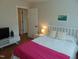 Bedroom featuring a bright pink throw with hardwood floors and a view to the front of the house at 5531 Autry Rd, Rocky Mount, NC 27803