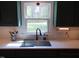 Kitchen with stainless steel sink, white countertops, updated faucet, and view of the backyard at 5531 Autry Rd, Rocky Mount, NC 27803