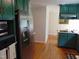 Modern kitchen featuring stainless steel appliances, green cabinets, and hardwood floors at 5531 Autry Rd, Rocky Mount, NC 27803