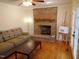 A cozy living room features a brick fireplace, comfortable sofa, and hardwood floors at 5531 Autry Rd, Rocky Mount, NC 27803