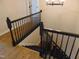 View of a wooden staircase with dark railings and modern wood flooring at 5531 Autry Rd, Rocky Mount, NC 27803