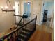 Bright hallway featuring a wood staircase, chandelier lighting, and neutral wall colors at 5531 Autry Rd, Rocky Mount, NC 27803