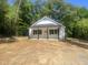 Charming home featuring a modern white exterior and black accents nestled among lush trees at 5875 Green Pine Rd, Cedar Grove, NC 27231