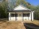Eye-catching home with a contrasting color scheme with a welcoming porch and crisp white siding, nestled in a wooded area at 5875 Green Pine Rd, Cedar Grove, NC 27231