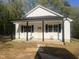 Charming new build featuring white siding, a covered porch with black accents, and a well-lit front entry at 5875 Green Pine Rd, Cedar Grove, NC 27231