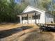 Stylish new home showing white siding and black trim, complemented by the natural surroundings and a convenient trailer at 5875 Green Pine Rd, Cedar Grove, NC 27231