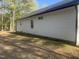 Exterior side shot of the home showing white siding and windows, complemented by a well-maintained yard with lush greenery at 5875 Green Pine Rd, Cedar Grove, NC 27231