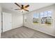 Bedroom featuring carpeted floors, a ceiling fan, and two large windows providing natural light at 624 S Kennelman Cir, Wendell, NC 27591