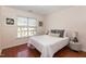 Cozy bedroom with a large window, hardwood floors, and a comfortable bed with decorative pillows at 8721 Owl Roost Pl, Raleigh, NC 27617