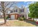 Two-story townhome featuring neutral siding, brick accents, a single-car garage, and landscaped front yard at 8721 Owl Roost Pl, Raleigh, NC 27617