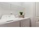 Well-organized laundry room with washer, dryer, overhead rack, and decorative accents at 8721 Owl Roost Pl, Raleigh, NC 27617