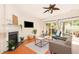 Inviting living space with hardwood floors, fireplace, ceiling fan, and sliding glass doors offering backyard views at 8721 Owl Roost Pl, Raleigh, NC 27617