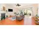 Bright living room with wood floors, a fireplace, a ceiling fan, and sliding glass doors to the backyard at 8721 Owl Roost Pl, Raleigh, NC 27617