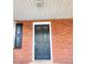 Close-up of the front door on a classic brick facade with black shutters at 919 E Main St, Haw River, NC 27258