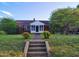 Charming brick home featuring a quaint front porch and well-maintained landscaping at 919 E Main St, Haw River, NC 27258