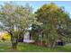 Exterior view featuring trees, partial view of a brick home with enclosed front porch at 919 E Main St, Haw River, NC 27258