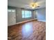 Cozy living room with wood flooring, neutral walls, and a ceiling fan at 919 E Main St, Haw River, NC 27258