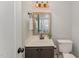 Half bathroom with an accent mirror, charming vanity, and modern fixtures at 9904 Erinsbrook Dr, Raleigh, NC 27617