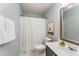 Cozy bathroom with pastel blue walls, shower with curtain, toilet, and wood-trimmed vanity at 9904 Erinsbrook Dr, Raleigh, NC 27617