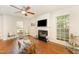 Bright living room features a fireplace, hardwood floors, and ceiling fan at 9904 Erinsbrook Dr, Raleigh, NC 27617
