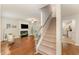 Bright living room features a fireplace, hardwood floors, and staircase at 9904 Erinsbrook Dr, Raleigh, NC 27617