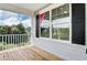 Charming covered porch with wood flooring, white railings, and black shutters at 0 Sawmill, Cedar Grove, NC 27231