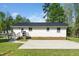 Back exterior of the home features a ramp, a parking pad, with green grass surrounding the area at 1017 S Second Ave, Siler City, NC 27344