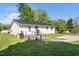 View of the backyard featuring the home's exterior, a ramp and parking pad surrounded by green grass at 1017 S Second Ave, Siler City, NC 27344