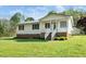 Charming home featuring a brick foundation, white siding, covered porch, and well-maintained lawn at 1017 S Second Ave, Siler City, NC 27344