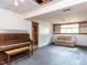 Spacious basement with an old upright piano and vintage-style couch at 103 Wesker Cir, Durham, NC 27703