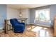 Sunlit living room with hardwood floors, large window, and cozy blue armchair at 103 Wesker Cir, Durham, NC 27703