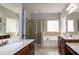 Bathroom featuring dual sink vanity, walk-in shower, and a soaking tub at 104 Mainline Sta, Morrisville, NC 27560