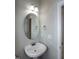 Cozy powder room boasts a pedestal sink, decorative mirror, and modern lighting at 104 Mainline Sta, Morrisville, NC 27560