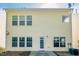 The back exterior of the yellow home features a door to the patio and several windows at 104 Mainline Sta, Morrisville, NC 27560