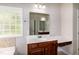 Bright bathroom with a large window above a garden tub and vanity with a white countertop and dark wood cabinets at 104 Mainline Sta, Morrisville, NC 27560