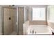 Primary bathroom featuring a glass-enclosed shower and separate soaking tub with large window at 104 Mainline Sta, Morrisville, NC 27560