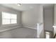 Spacious bonus room with plush carpeting, natural light, and staircase at 104 Mainline Sta, Morrisville, NC 27560