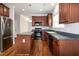 Spacious kitchen with black appliances, a center island, and warm wood-look flooring at 104 Mainline Sta, Morrisville, NC 27560