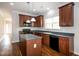 Kitchen featuring an island, stainless sink, black appliances, and rich wood cabinetry at 104 Mainline Sta, Morrisville, NC 27560