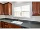 Kitchen view showcasing the stainless steel sink with a bright window, and rich wood cabinetry at 104 Mainline Sta, Morrisville, NC 27560