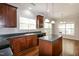Well-lit kitchen with dark wood cabinets, an island, and hardwood floors at 104 Mainline Sta, Morrisville, NC 27560