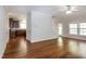 Open-concept living room featuring hardwood floors, a ceiling fan, and large windows for natural light at 104 Mainline Sta, Morrisville, NC 27560