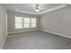 Spacious primary bedroom with tray ceiling, ceiling fan, plush carpeting, and natural light at 104 Mainline Sta, Morrisville, NC 27560