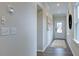 Hallway with beautiful hardwood floors and neutral paint, leading to the front door at 105 Sepals Pl, Wendell, NC 27591