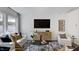 Modern living room with white sofas, patterned rug, sleek furniture, and ample natural light from large windows at 107 Sepals Pl, Wendell, NC 27591