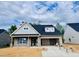 New home with gray shingles, two-car garage, covered front porch, and unfinished landscaping at 1073 Fairhaven Dr # 52, Mebane, NC 27302