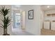 Hallway with laundry room, white walls, carpet floor, and decorative plant at 111 Sepals Pl, Wendell, NC 27591