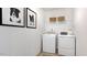 Laundry room with modern washer and dryer and overhead shelving at 111 Sepals Pl, Wendell, NC 27591