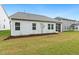 View of the backyard with a screened in porch, lawn and fresh landscaping, new construction at 1116 Ciandra Barn Way, Apex, NC 27523